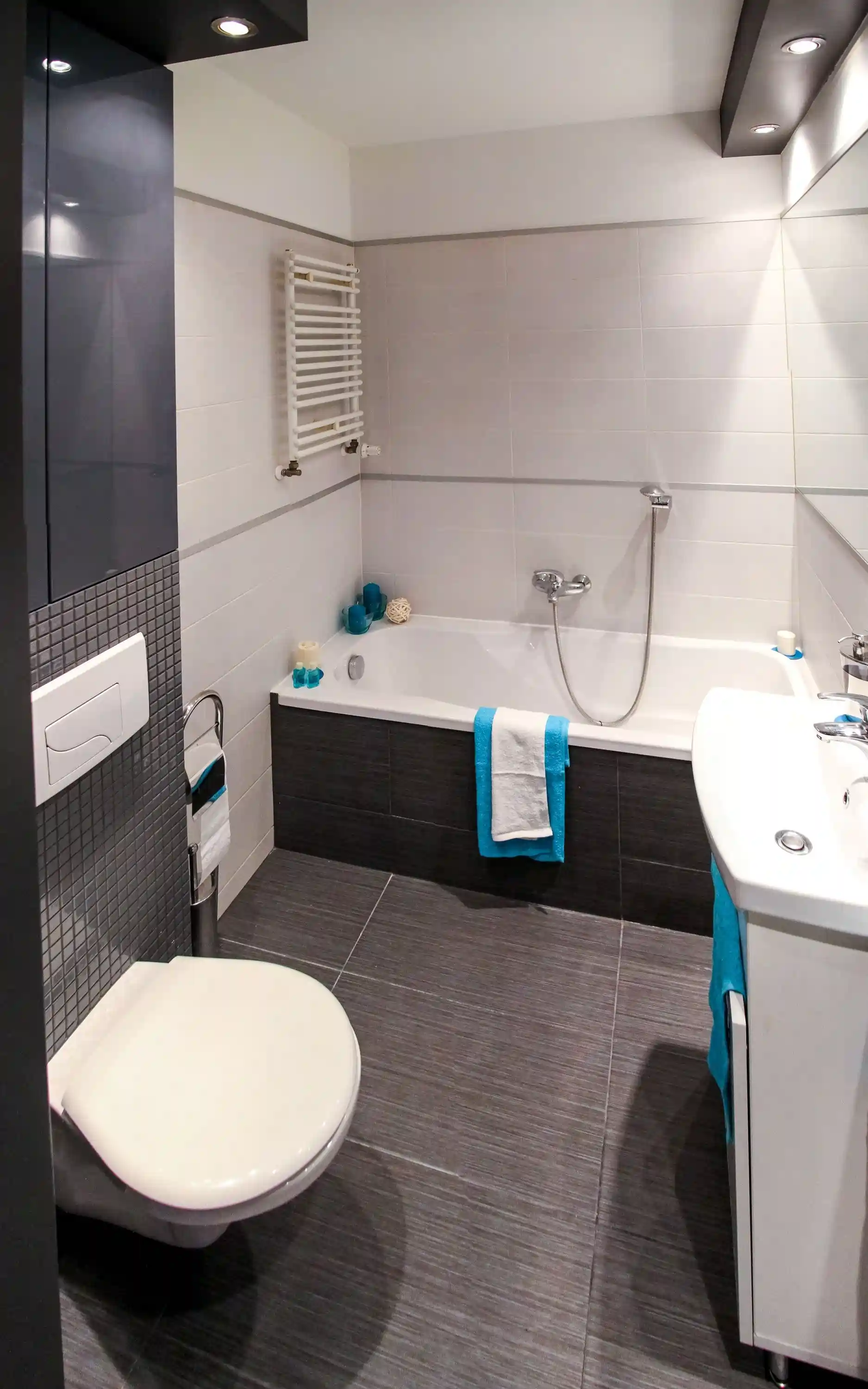 Dark gray mosaic tile bathroom with built-in bathtub in Carson